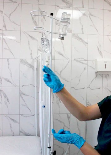 Капельница с раствором Ципрофлоксацином Врач поправляет капельницу